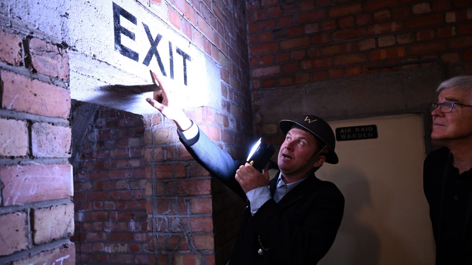 Man pointing at exit sign